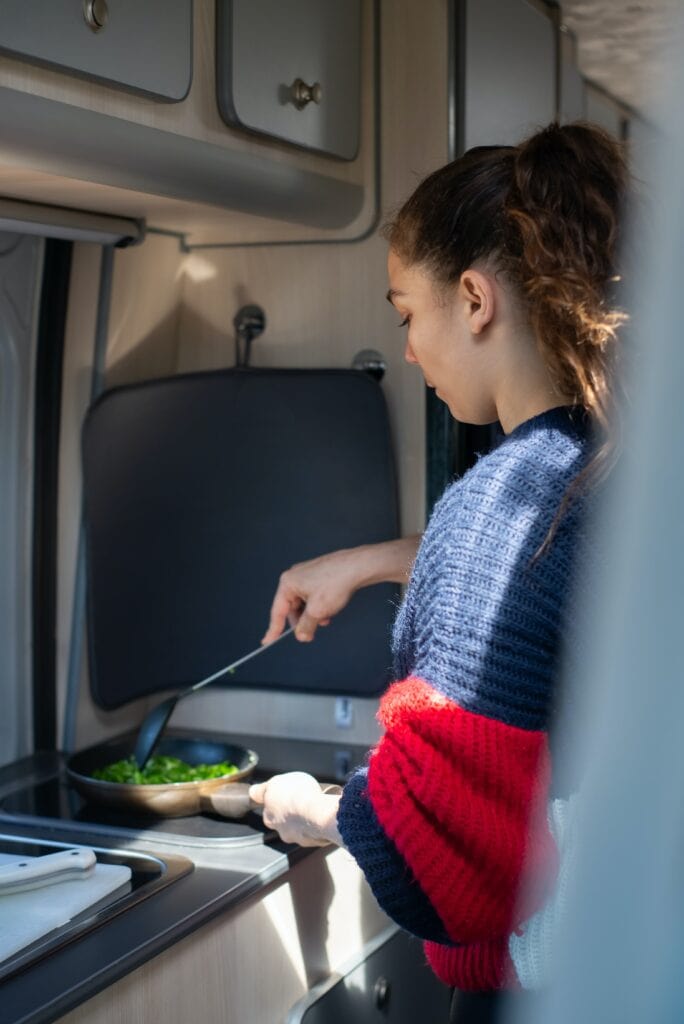 Woman Cooking on Campervan Electrical Stove