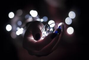 String of LED fairy lights being held in hand in a dark setting, highlighting professional electrical wiring and lighting installation by Westline Electricians Perth.